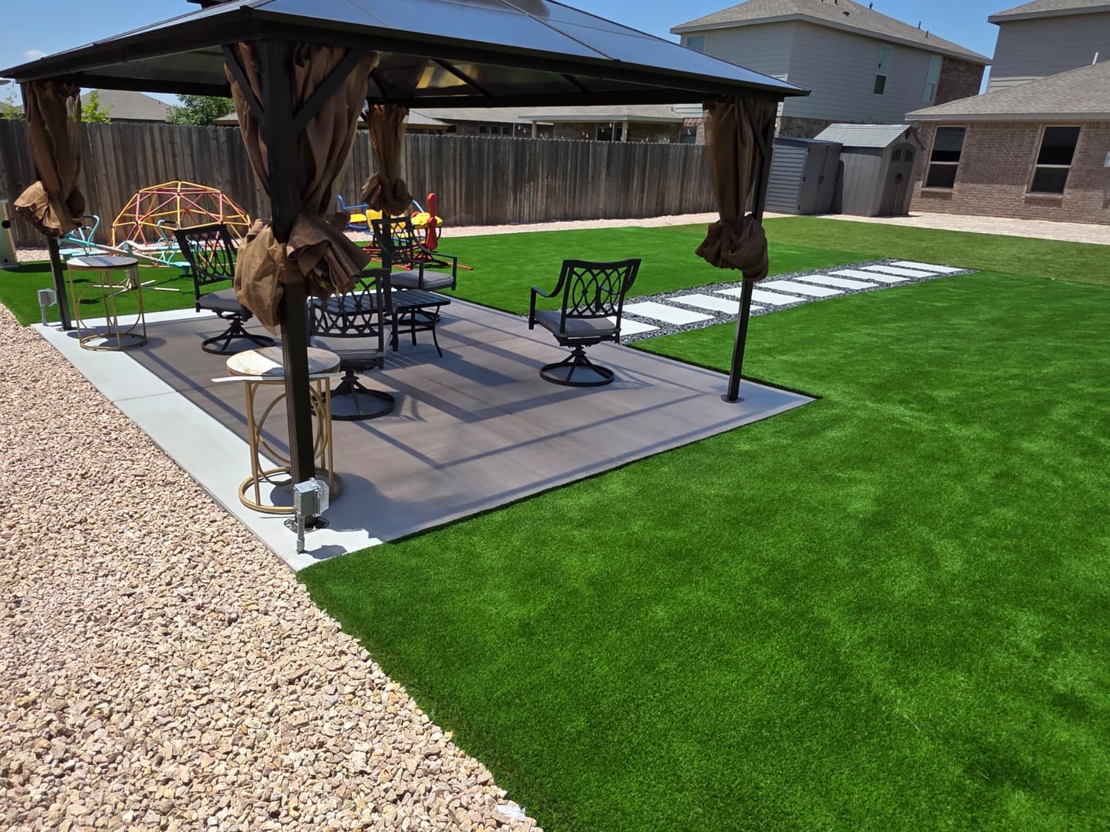 Transforming the backyard with artificial grass, a stepped flagstone path, and a decorative stone border.